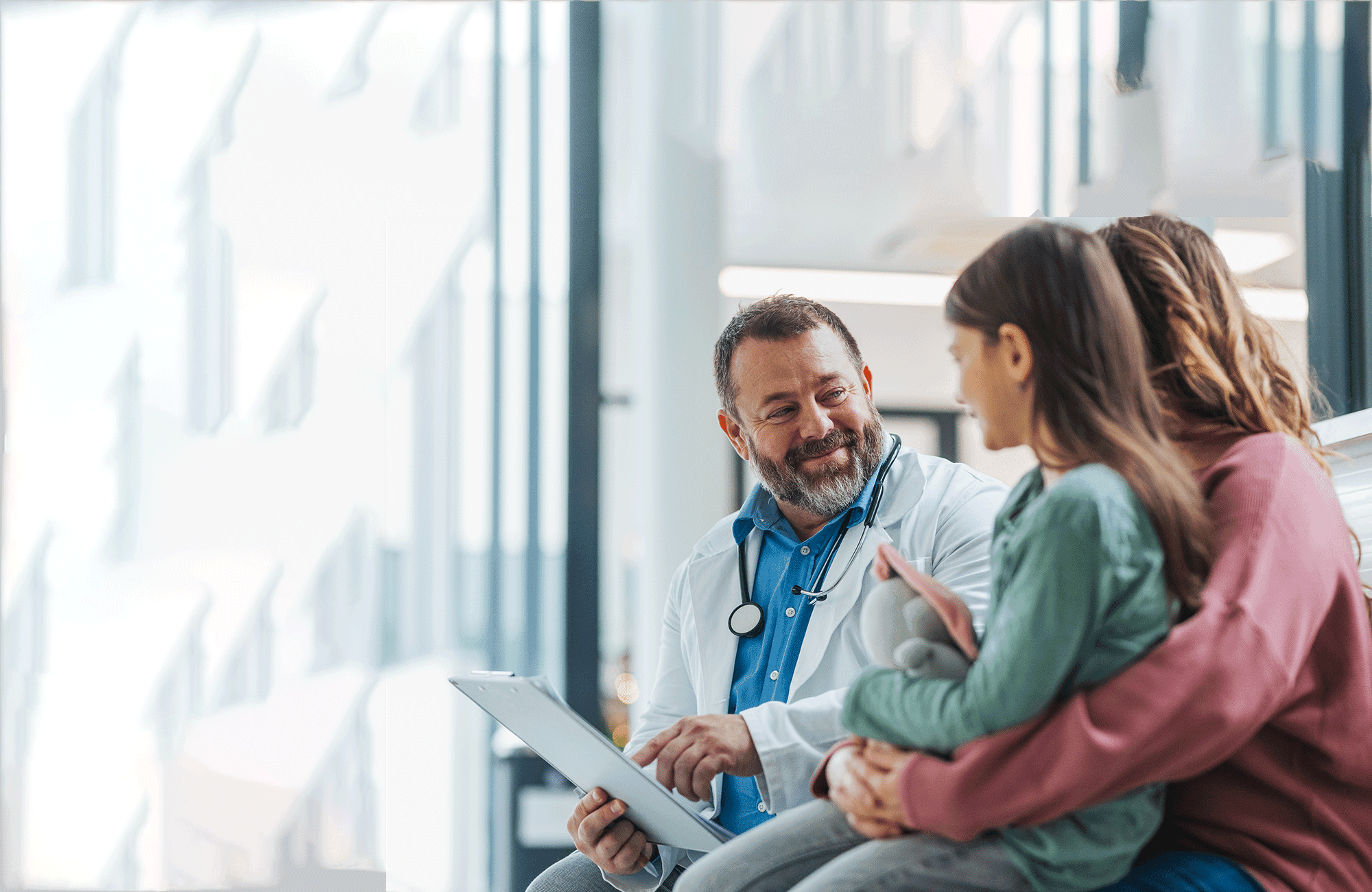 A doctor reviewing care details with a parent and child